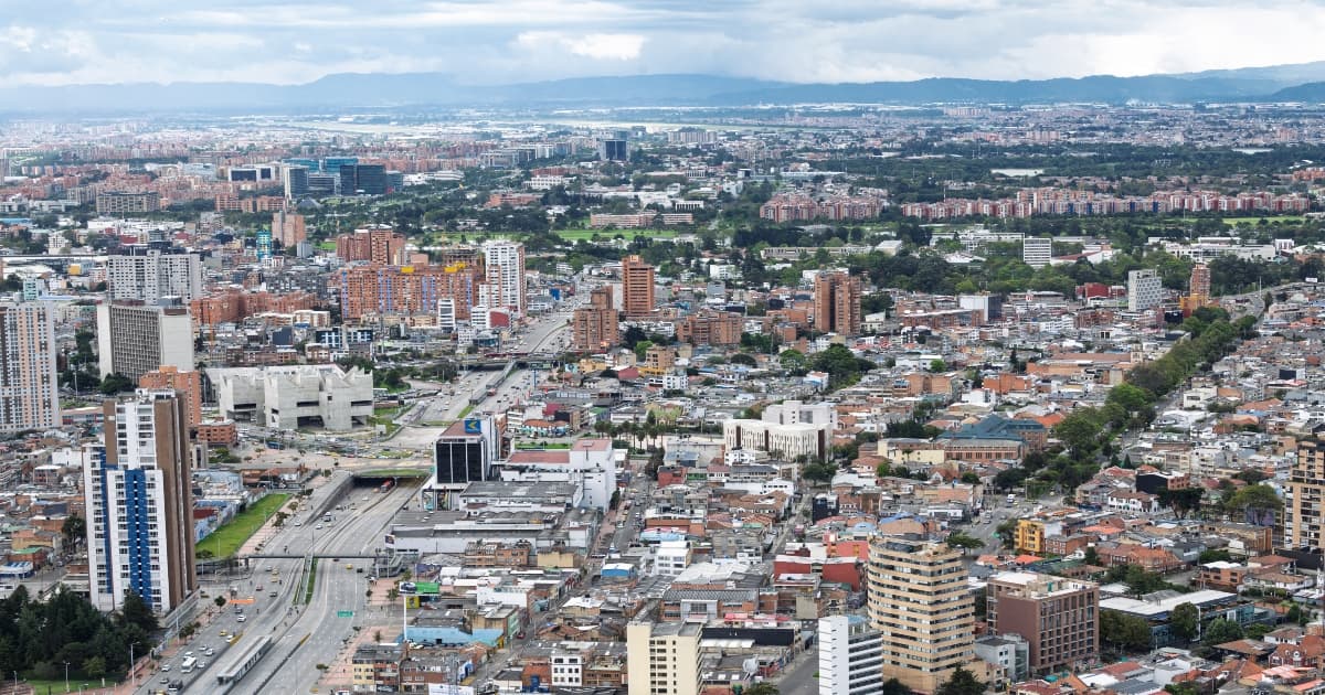 Vista panorámica de Bogotá con edificaciones de diferentes alturas, vías principales y zonas densamente urbanizadas para referenciar el pronóstico del tiempo y estado del clima.