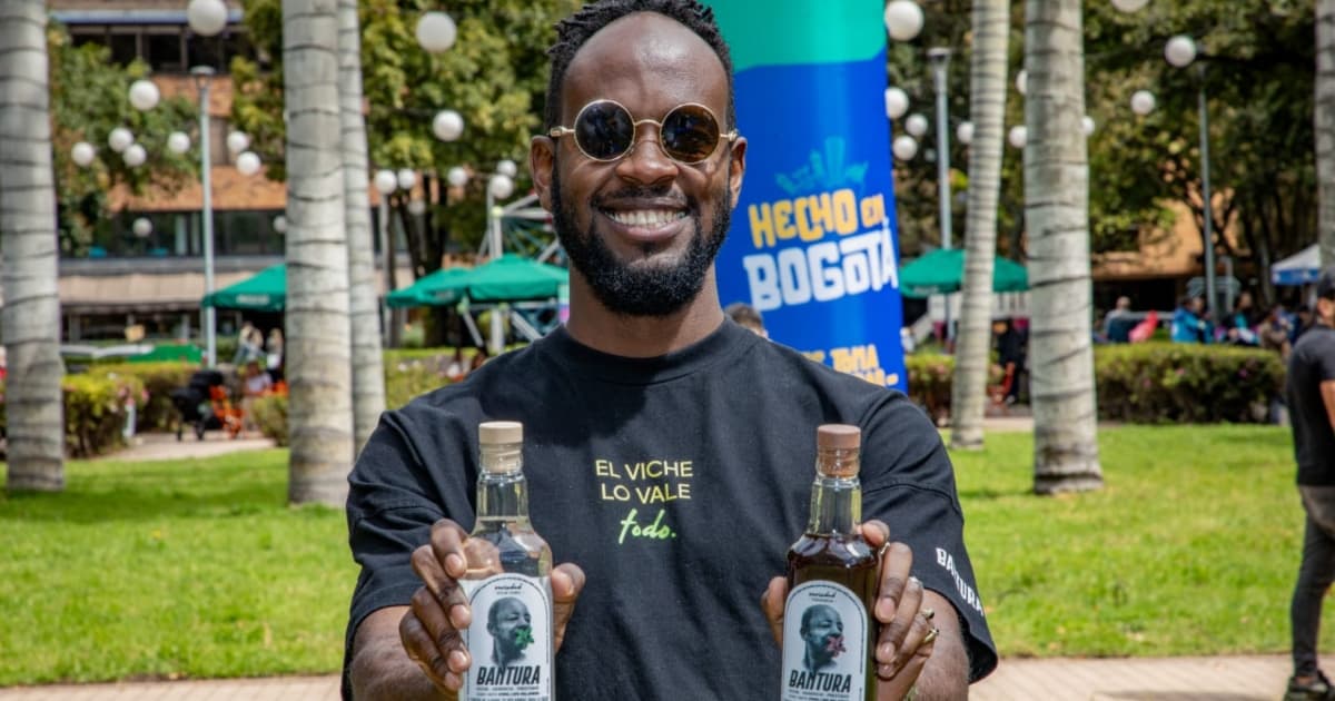 Comerciante enseñando dos botellas de viche.