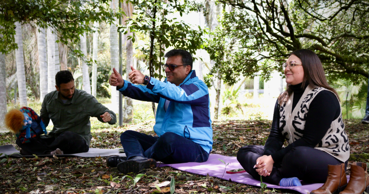 Foto del secretario de salud sentado en pasto