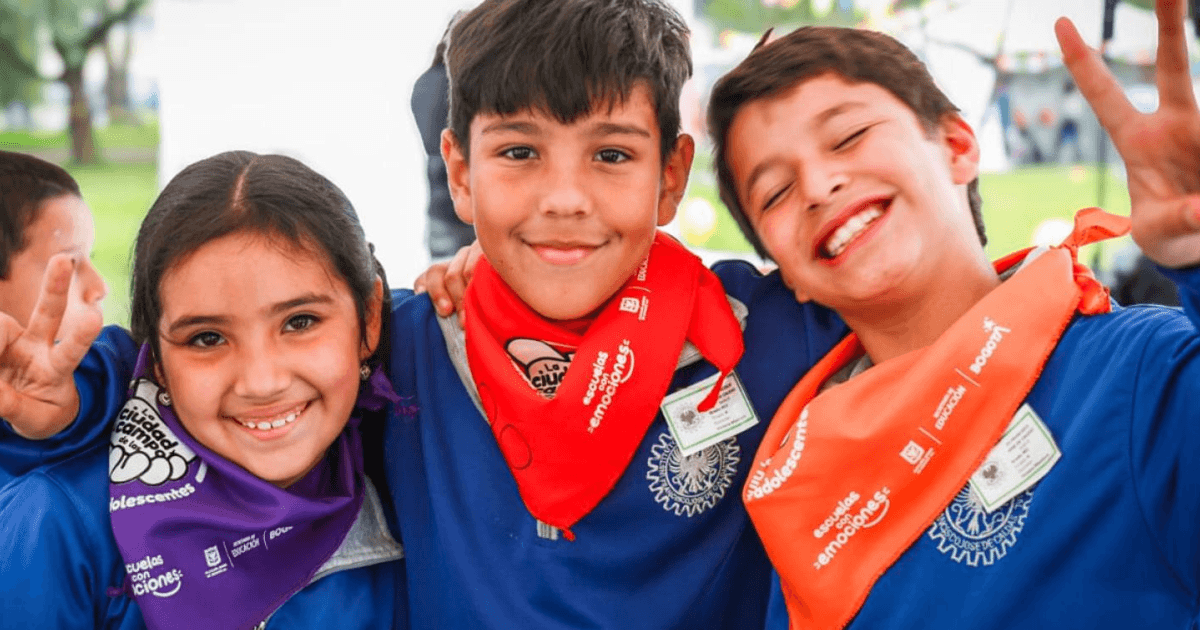 Foto una niña y dos niños sonriendo.