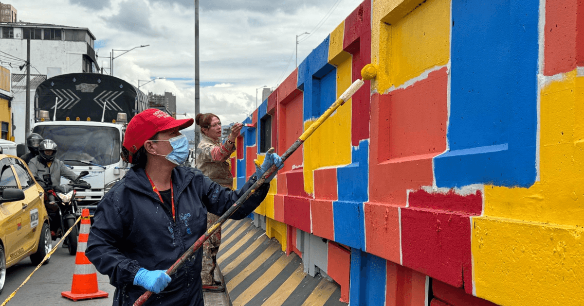 Defensoras del espacio público pintando un bajo puente en Bogotá.