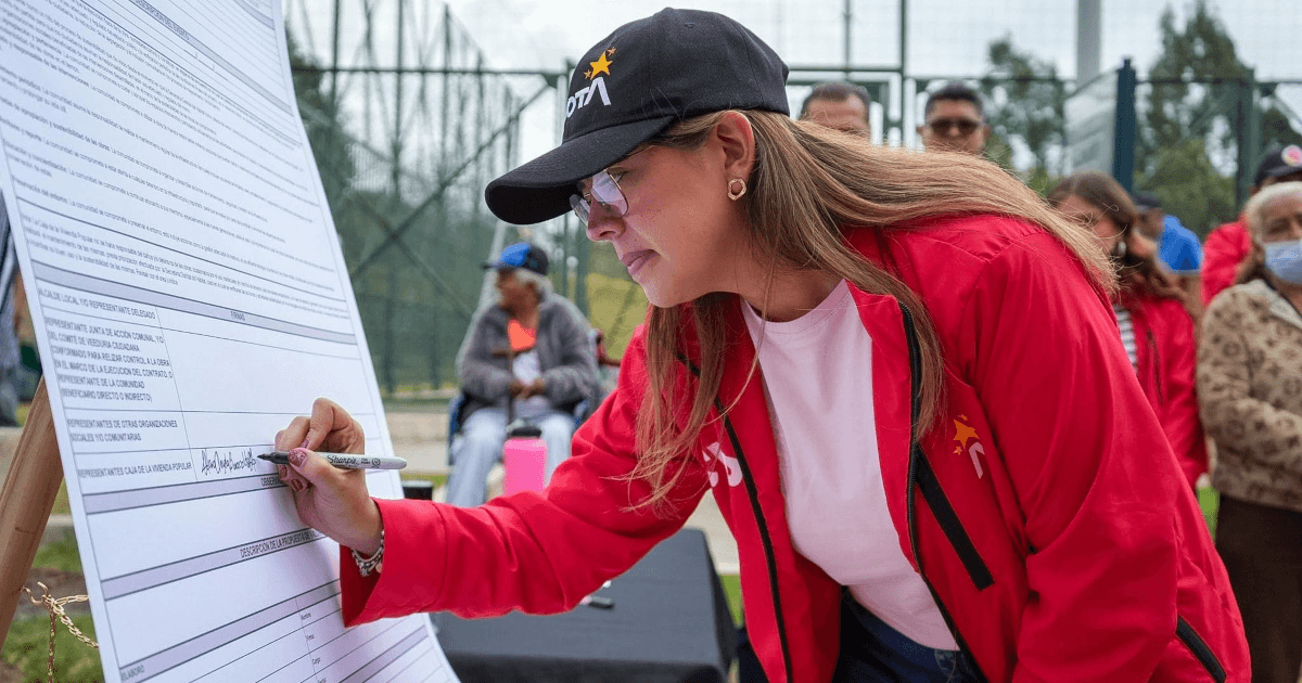 Foto que muestra una mujer firmando un documento