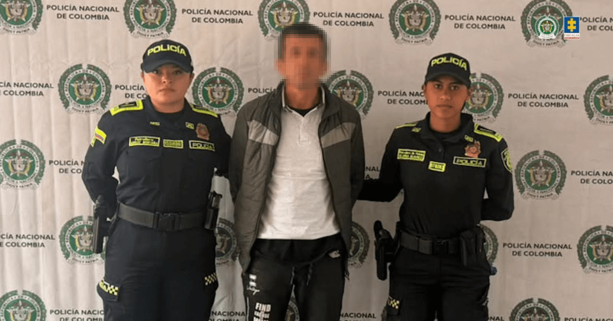 Foto de hombre capturado en medio de dos policías.