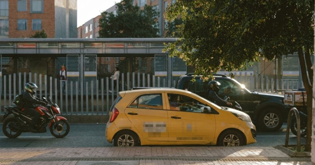 Foto donde se encuentra un taxi y otros vehículos en una vía de Bogotá