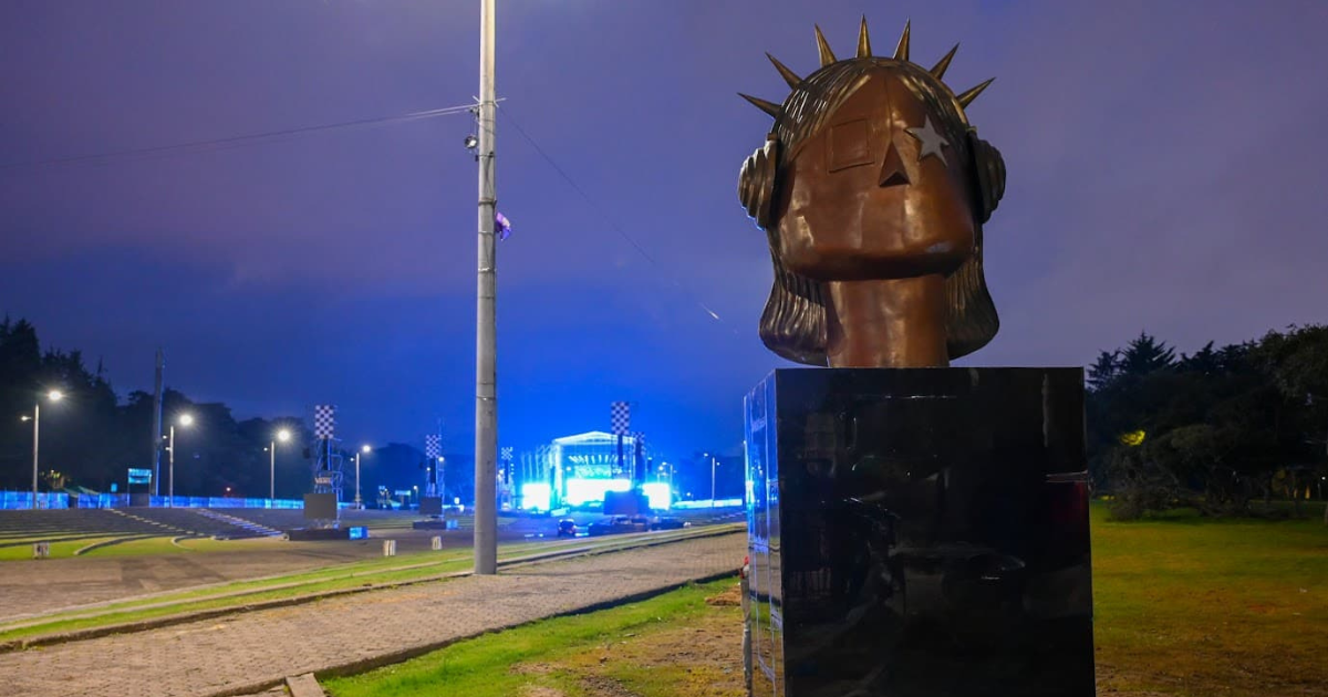 Imagen de la escultura 'La Rockera' con las tarimas de Rock al parque 2026 de fondo