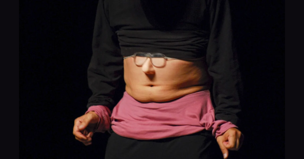 Imagen del cuerpo de un hombre que viste de negro y su estómago está descubierto.