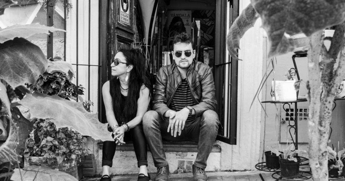 Imagen de un hombre y una mujer sentados a la entrada de una puerta