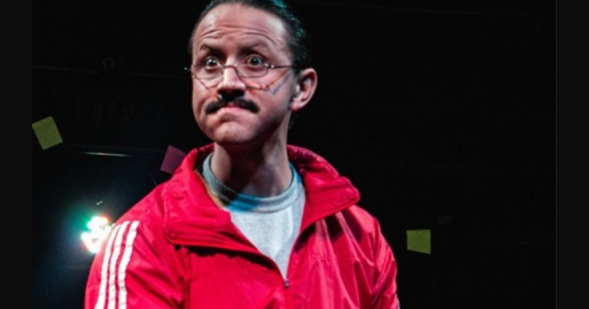 Imagen de hombre mayor que usa gafas y chaqueta roja con cara de angustia con un fondo oscuro