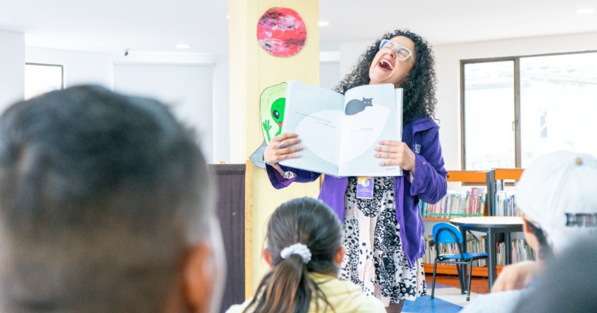 Imagen de una persona con un libro abierto sonriendo