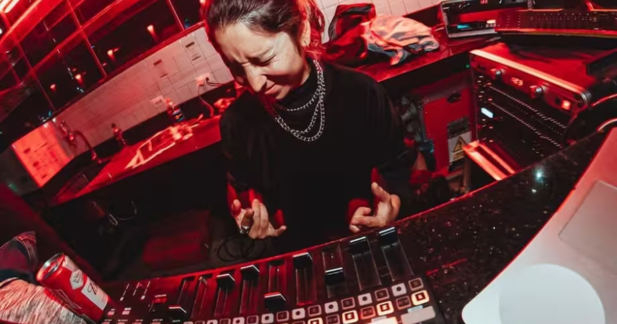 Imagen de una mujer jovén tocando música en una consola color negro