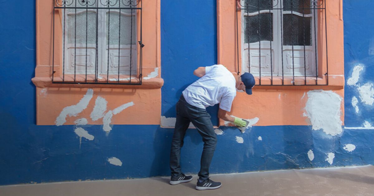Imagen de persona reparando una pared