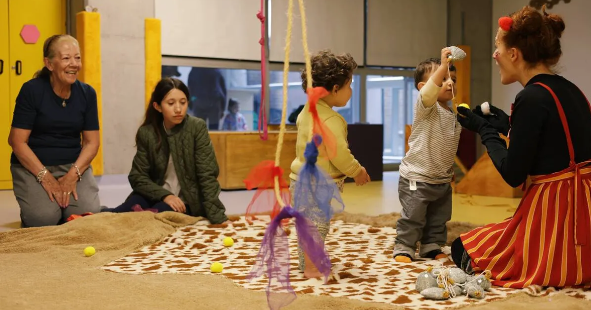 Imagen de varios bebés en taller de trapitud juntos a sus padres y cuidadores