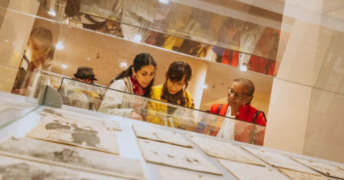 Imagen de tres mujeres observando una exposición