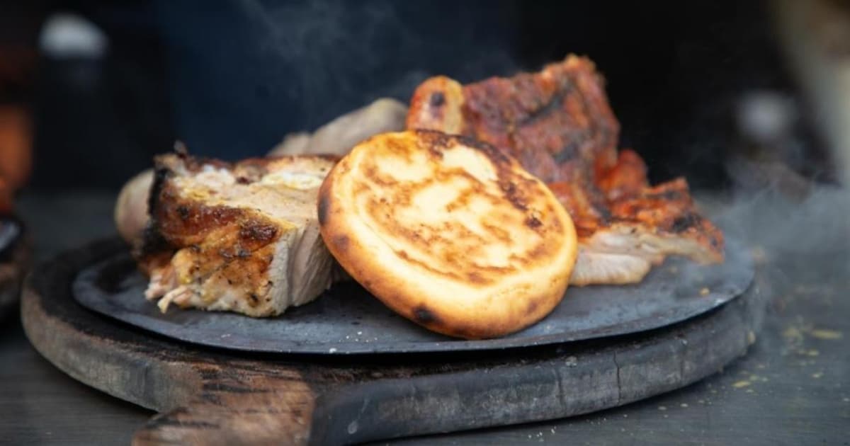 Foto de un plato con carnes, arepa, papa y otros ingredientes de una picada o parrillada en Bogotá.