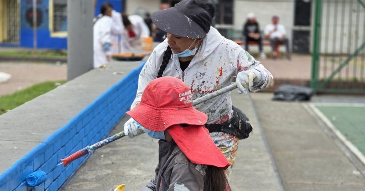 Imagen de dos mujeres pintando ladrillos de espacio público