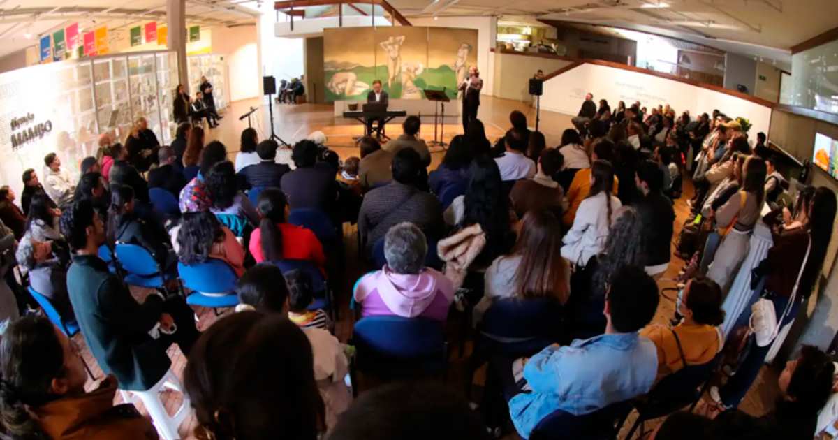 Foto que muestra un grupo de personas en un auditorio en un concierto 