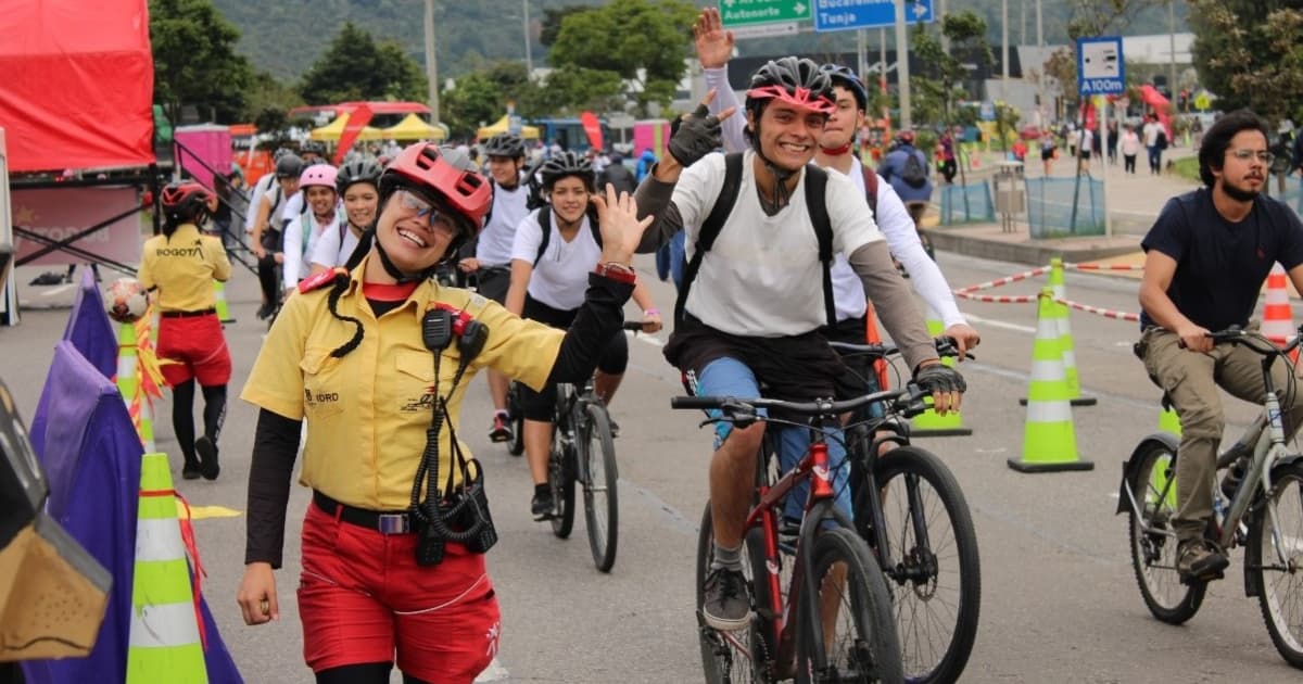 Personas en bicicleta durante Ciclovía en Bogotá acompañadas por Guardianes de la Ciclovía