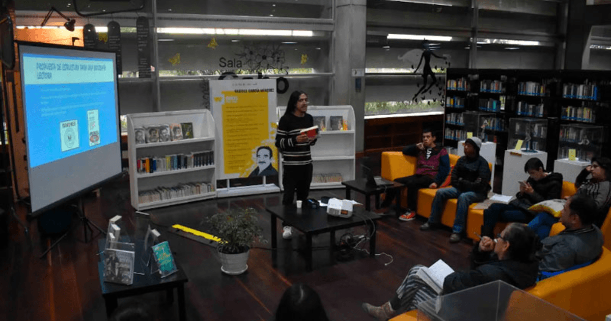 Personas escuchando una conferencia en una biblioteca.