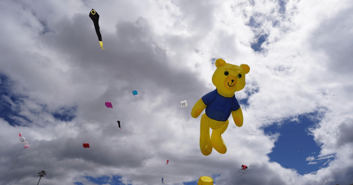 Cometas de distintas formas y colores vuelan en el cielo, incluida una cometa gigante con forma de oso elevadas en Bogotá.