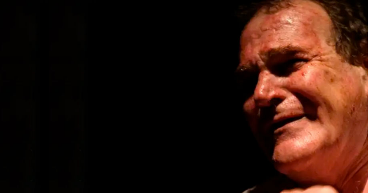 Imagen de un hombre mayor con cara de angustia en un recinto que se ve oscuro.