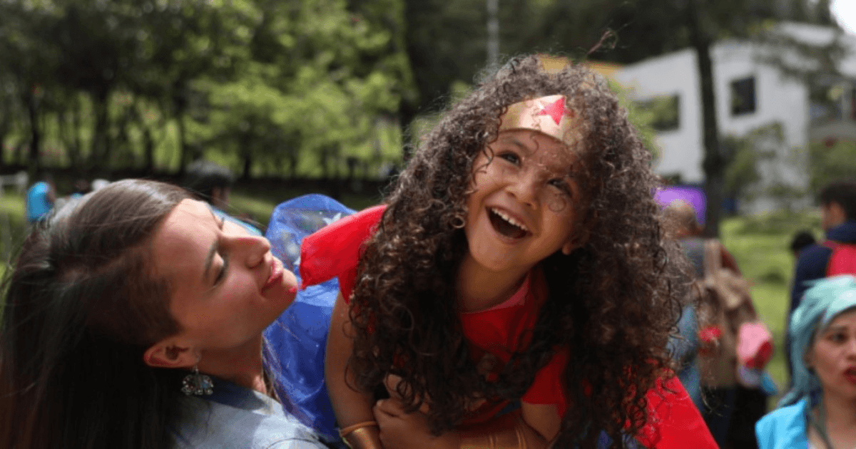 Imagen de una mujer y una niña dizfrazada de mujer maravilla