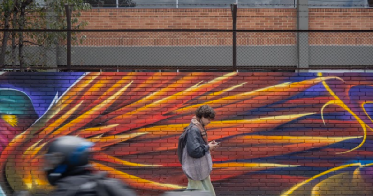 Imagen de un hombre que recorre a pie un mural.