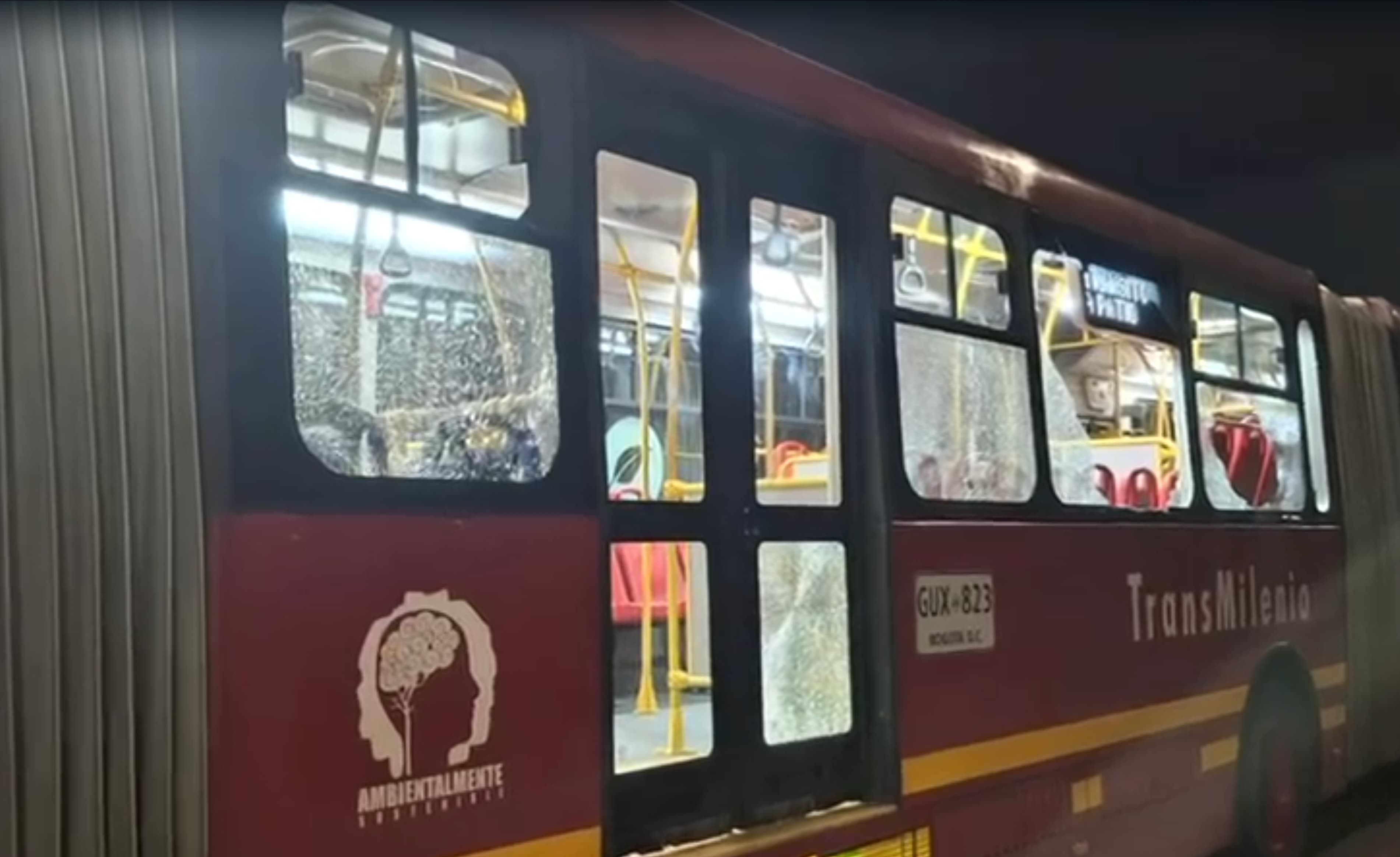 Bus articulado con ventanas rotas.