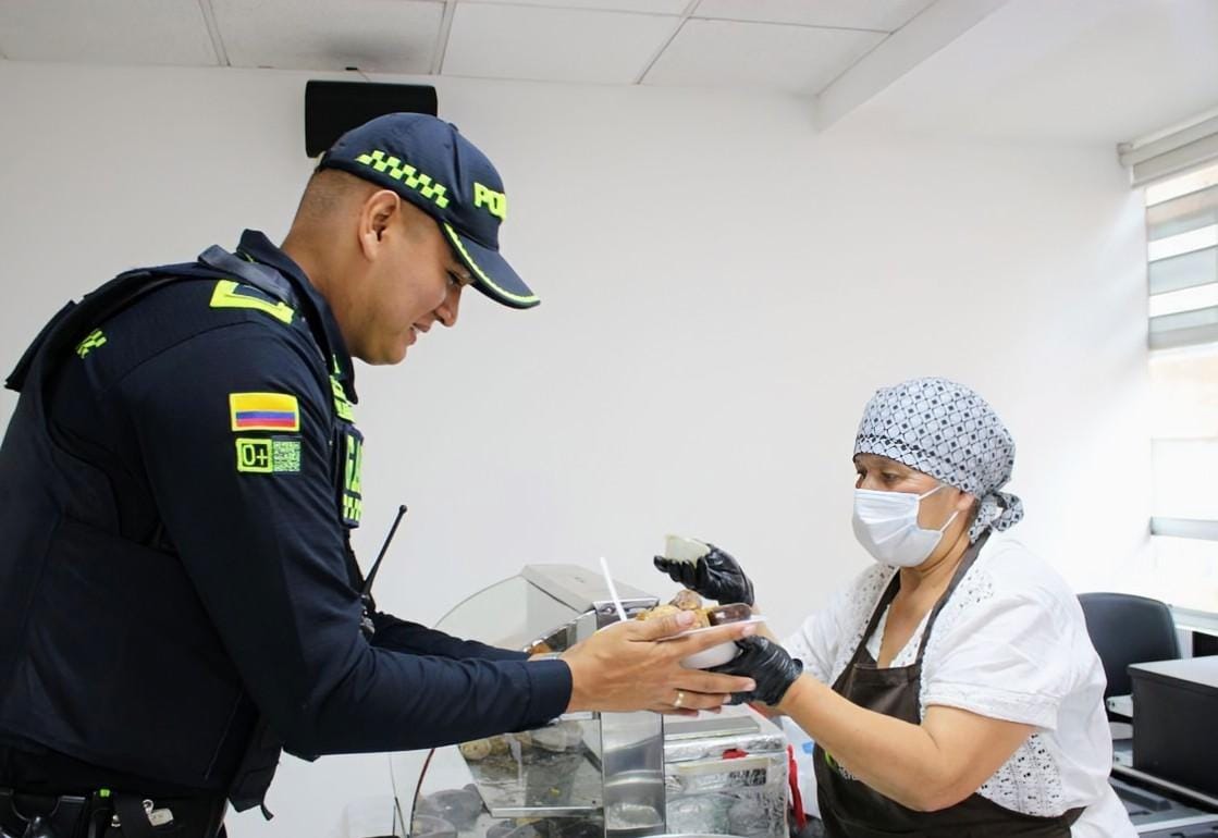 Foto que muestra un policía hablando con una señora 