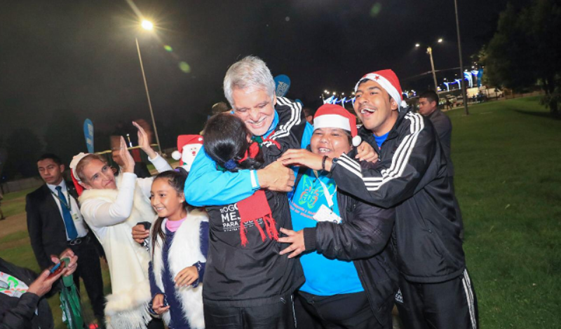 El alcalde Peñalosa abraza a un grupo de niños en la inauguración de una de las canchas de la ciudad. Foto: Alcaldía de Bogotá.