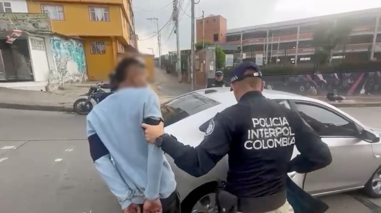 En Bogotá, fue capturado, a través de una notificación roja de interpol, un ciudadano colombiano solicitado en extradición por el delito de homicidio. La Dijin e INTERPOL en coordinación con la Policía de Investigaciones de Chile-PDI, lograron la captura mediante notificación roja, en el barrio Las Lomas en el sur de Bogotá, de Marlon Stick Duque Garzón, requerido por el Juzgado de Garantía de La Serena de la Ciudad de Santiago de Chile, por el delito de homicidio.   No olvides leer: 25 armas cortopunzantes incautadas deja operativo en el centro de Bogotá Marlon Stick Duque Garzón es acusado de formar parte de un grupo de cuatro agresores, donde su rol criminal estaría relacionado con la participación activa en el ataque con arma cortopunzante contra un hincha de futbol colombiano de 23 años, identificado como Luis Alberto Cossio Cardona, quien falleció debido a las múltiples heridas en La Serena Chile, así como la lesión de Eduardo Jacob Ramírez Camacho, producto de una riña entre seis personas en la terminal de buses de La Serena, el día 25 de abril de 2024, tras el partido de Copa Libertadores entre Millonarios y Palestino. Este trágico suceso generó conmoción tanto en Chile como en Colombia, resaltando la necesidad de abordar la no violencia asociada al fútbol y de fortalecer las medidas de seguridad para los aficionados que asisten a eventos deportivos internacionales. El capturado fue puesto a disposición de la Fiscalía General de la Nación, a través de la Dirección de Asuntos Internacionales, a la espera de que las autoridades del país solicitante, realicen los trámites pertinentes para que se lleve a cabo su extradición. Aquí, una imagen del momento de la captura de  También te puede interesar: Judicializado hombre acusado de asesinar a recluso en cárcel La Picota de Bogotá Dentro de la investigación,  el pasado 28 de septiembre de 2024, en el barrio Villa Mayor de Bogotá, se realizó la captura del ciudadano colombiano Blas de Jesús Rivera Contreras, requerido por Chile por el delito de Homicidio