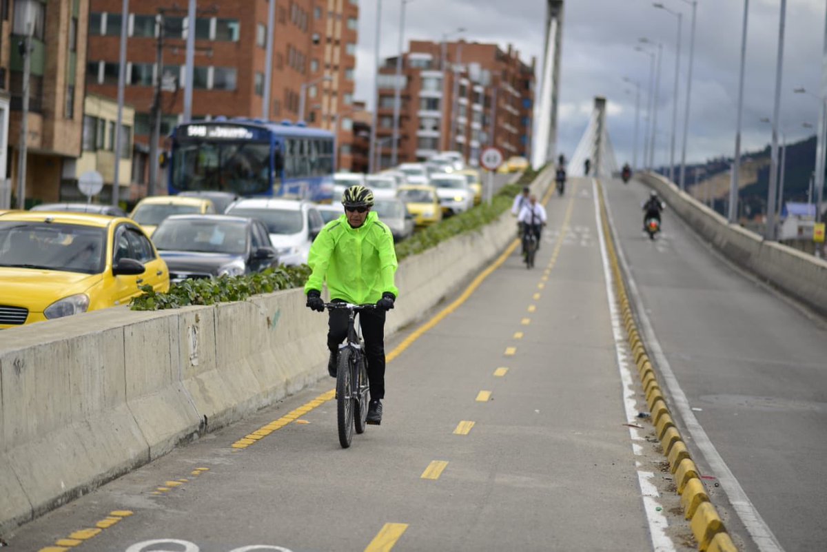 Biciusuario portando chaleco reflectivo en su bicicleta y usando la cicliruta