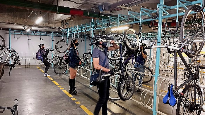 Personas dejando sus bicicletas en los cicloparqueaderos