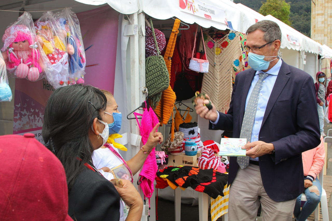 Embajador de Alemania en Colombia, Peter Ptassek charlando con las emprendedoras de una microempresa de muñecas