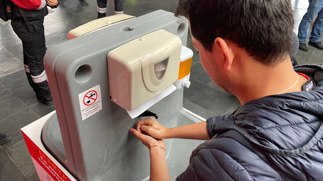 Usuario lava sus manos con agua y jabón en una estación de TransMilenio