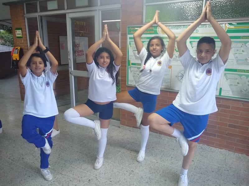 Estudiantes realizando una pose de yoga