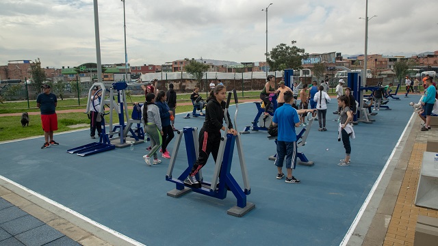 Un plano general de la parte de gimnasio, con varias personas haciendo ejercicio