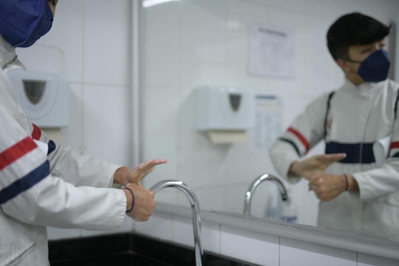 Imagen de un estudiante lavando sus manos