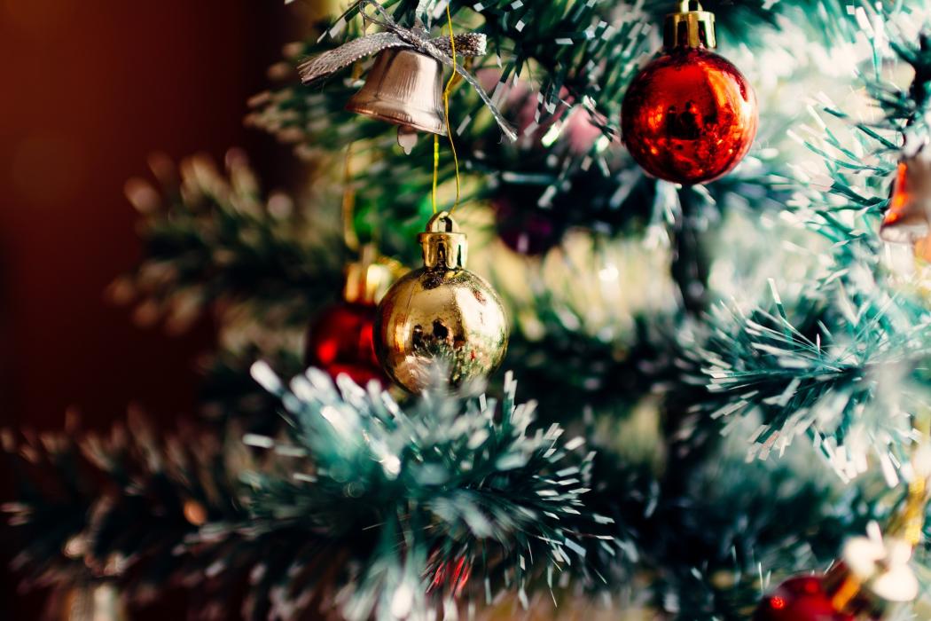 Primer plano de un árbol de navidad, con varias bolas de colores decorando el árbol