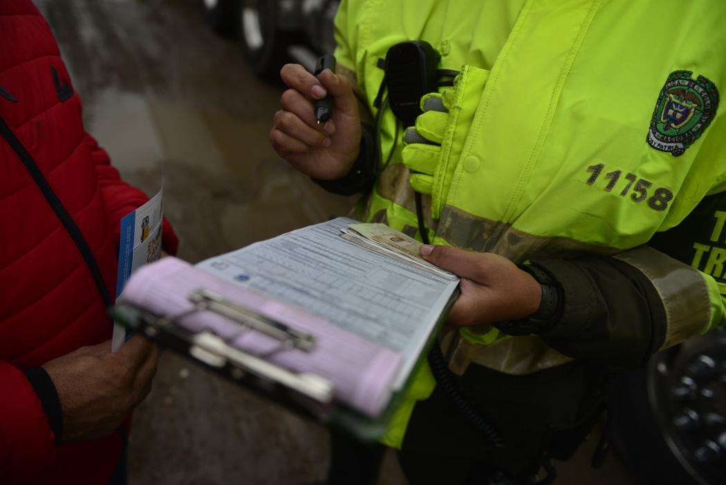 Un Policía multando con una libreta multando a un ciudadano 