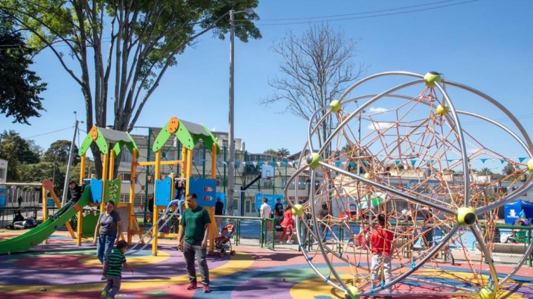 Foto general del uno de los parque inaugurados en Engativá, se observan varios juegos para niños, algunos adultos, padres y niños jugando