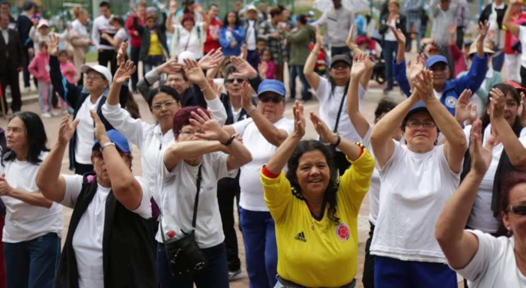 Un grupo de mujeres mayores participan en un evento recreativo en un parque de Bogotá.