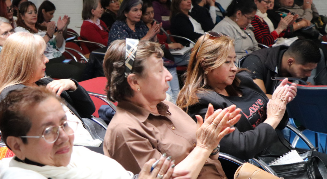 Mujeres bogotanas escuchan una conferencia, ellas serían las beneficiadas de la reducción de homicidios en Bogotá.