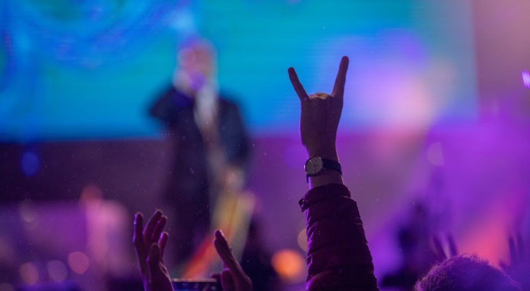 Un hombre alza su mano haciendo una señal en medio de una presentación de Rock al Parque 2019.