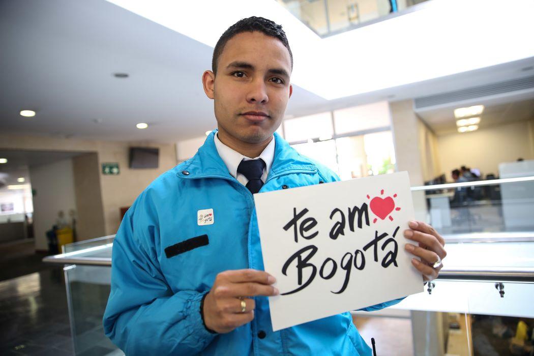 Imagen de un funcionario del Distrito con letrero de Te amo Bogotá