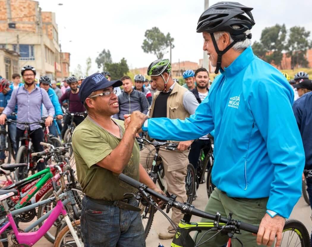 Imagen de Peñalosa dando la mano a un mecánico de bicicletas 