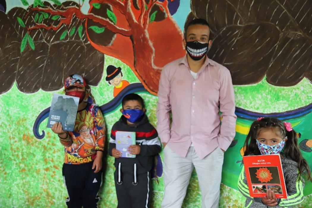 Javier Gualteros, junto a tres niños, que casa sábado se reúnen en la Biblioteca rural Santa Rosa