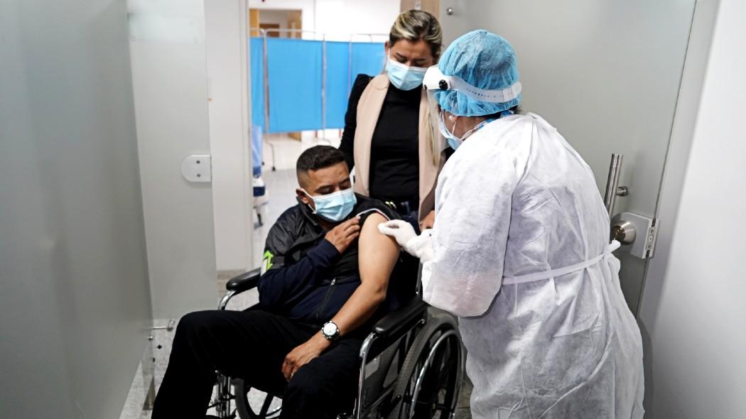 Persona en silla de ruedas vacunándose.