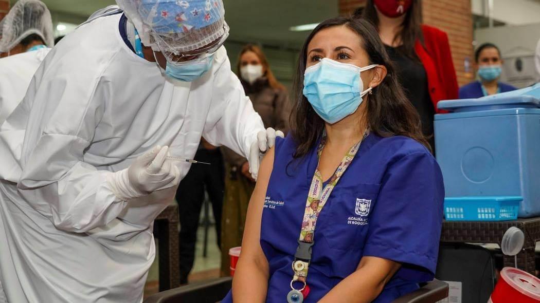 Imagen de una funcionaria en salud recibiendo la vacuna.
