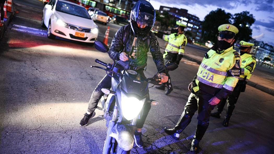 Motociclista junto a policía de tránsito.