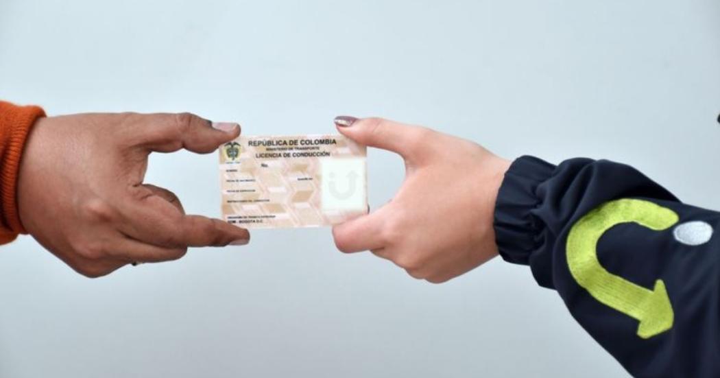 manos sosteniendo un pase de conduccion